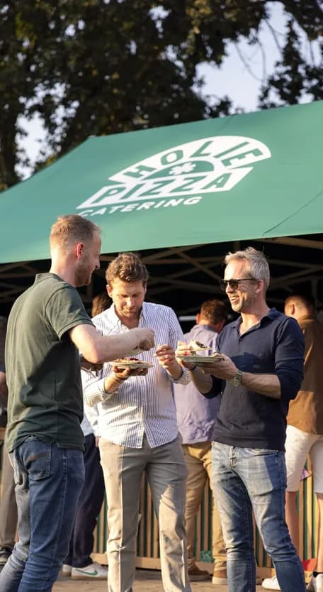 gasten genieten van een lekker stukje pizza van holie pizza op een evenement